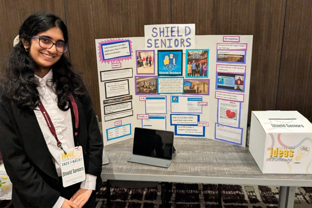 A teenage girl stands in front of a presentation board titled, “Shield Seniors”.