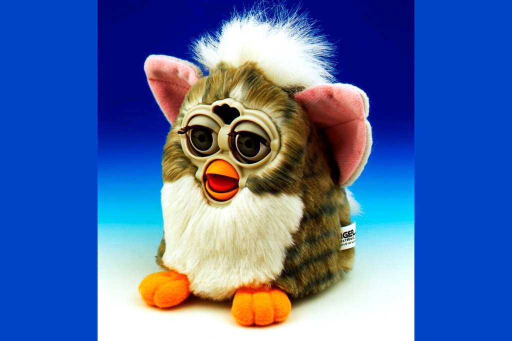 A brown, white, and black Furby against a blue background