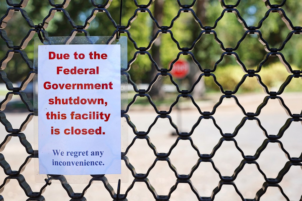 A sign posted on a fence that says, “Due to the Federal Government shutdown, this facility is closed. We regret any inconvenience.”