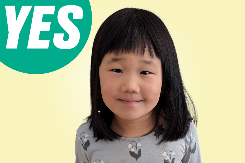 Portrait of a smiling young girl with short dark hair against a yellow background with a green circle labeled “YES.”