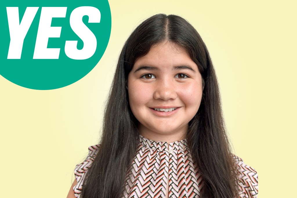 Portrait of a smiling girl with long dark hair in a patterned top against a yellow background with a green circle labeled “YES.”