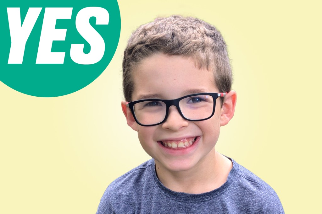 Portrait of a smiling boy with glasses against a yellow background with a green circle labeled “YES.”